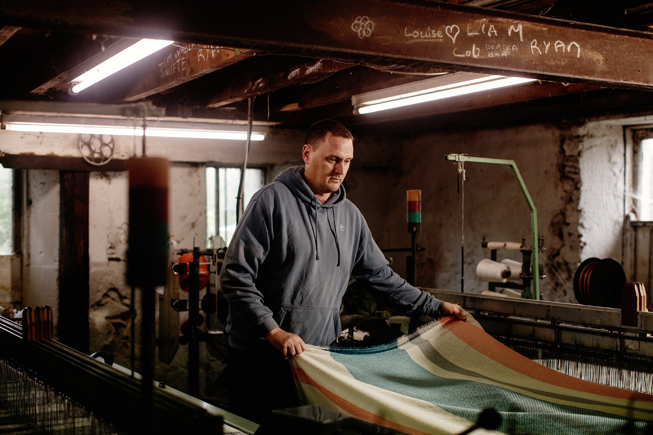 A man working with striped fabric at the Cushendale mill
