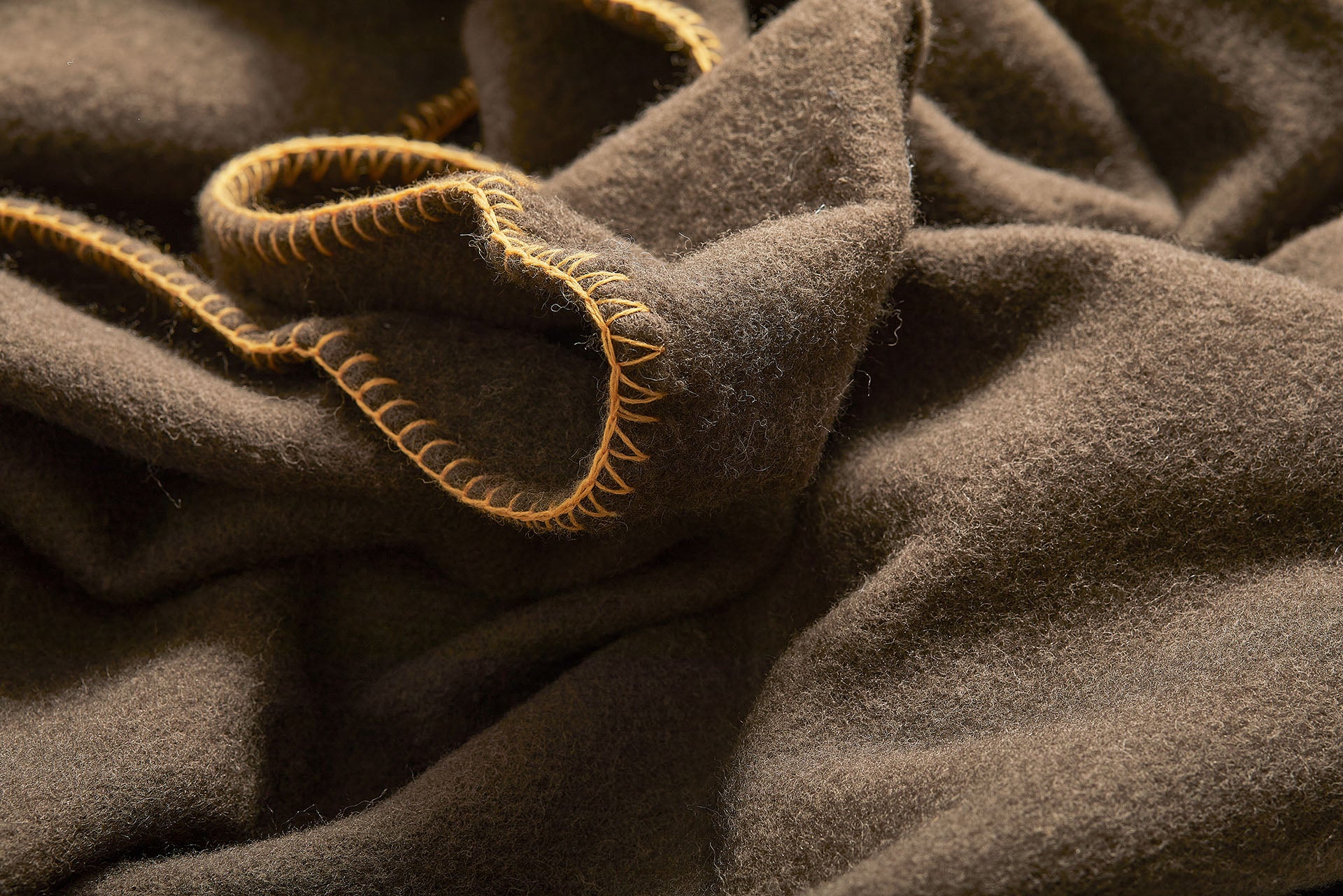 Dark brown blanket throw with light orange stitching