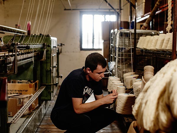 Portrait of Marty working with spools of thread at the mill