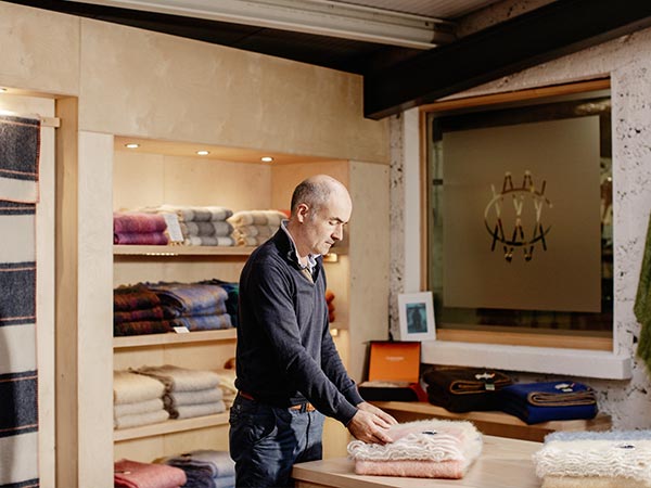 Portrait of Trevor folding scarves in the Cushendale show room